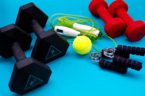 Exercise equipment weights, jump rope, tennis ball, hand grip strengthener Stock Photos