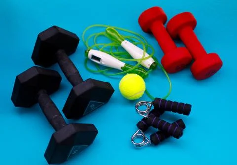 Exercise equipment. Weights, jump rope, tennis ball, hand grip strengthener Stock Photos
