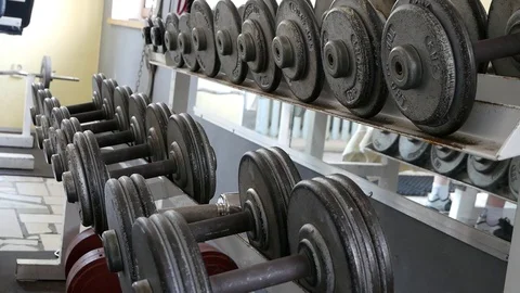Exercise in the gym. Choosing the right weight of the dumbbells. Stock Footage 92833420