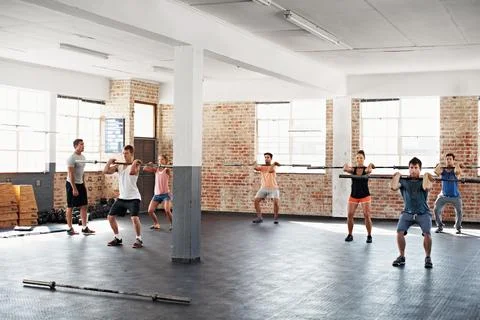 Exercise, instructor and people in gym together for strength challenge or weight Stock Photos