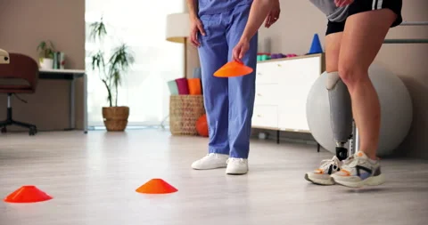 Exercise, legs or prosthetic with patient and physiotherapist in office for Stock Footage 283591991
