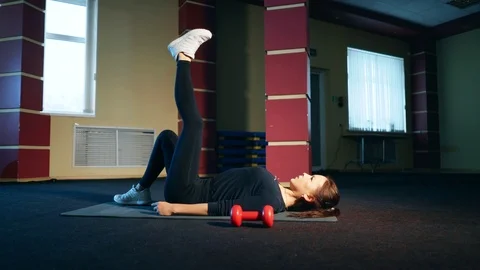 Exercise lifting the pelvis with one foot. The girl performs an exercise on the Stock Footage 104002807