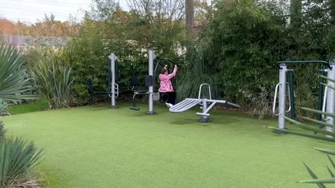Exercise machine on the public park. Happy child doing exercises in the street g Stock-Footage 301195538