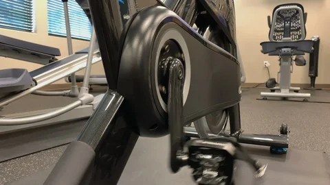 Exercise spin bike continuing to pedal with no one on it in an empty gym. Stock Footage 109530575