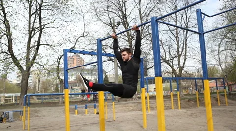 Exercise of a Young Athlete on a Horizontal Bar. Pulling up on the Bar With His Stock Footage 62252760