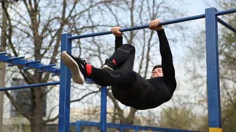 Exercises on the Bar, the Athlete Makes a Horizontal Suspension With Earth Stock Footage 62252642