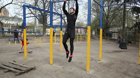 Exercises on the Bar, the Athlete Makes a Horizontal Suspension With Earth Stock Footage 62252715