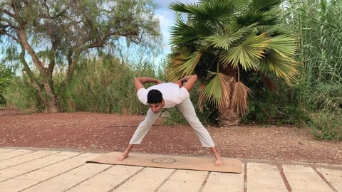 Exercises for flexibility in the morning in summer time on canary islands. Video stock 246481366