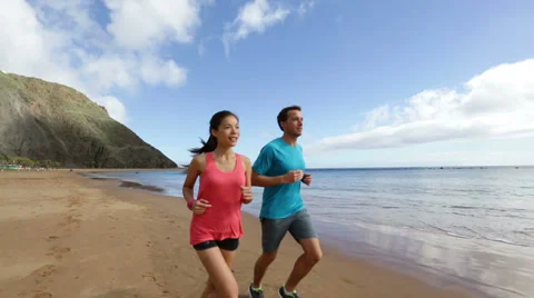 Exercising running couple jogging on beach Stock Footage 37597977