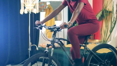Exercycle is getting used by an african lady in quarantine Stock Footage 267528459