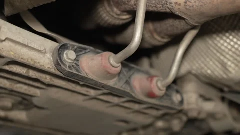 An exhaust pipe rubber hanger bracket is mounted under car. Stock Footage 341334093
