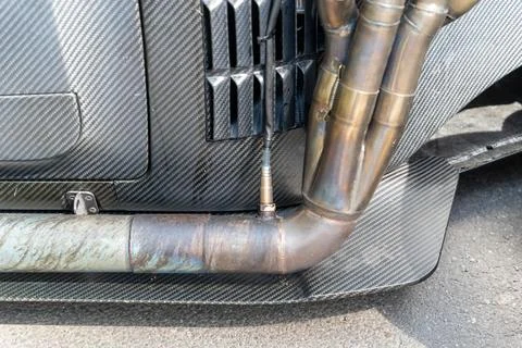 Exhaust system with lambda sensor and carbon fiber body in a sports car Stock Photos