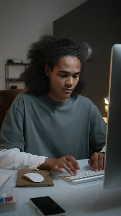 Exhausted Black Young Man Working Late at Night on Desktop Computer Stock Footage 348153248