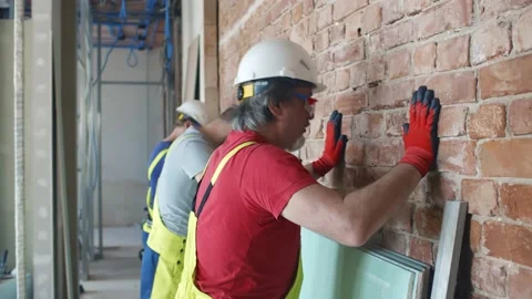 Exhausted builders hitting wall with heads in frustration Stock Footage 133635432