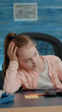 Exhausted child looking at computer for online classes Foto stock