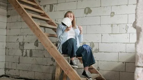 Exhausted construction worker sitting alone in unfinished residential house Stock Photos