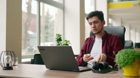 Exhausted customer support service worker removes headphones, finishes work Stock Footage 221092300