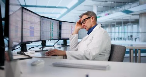 Exhausted Doctor In Hallway With Broken Computer Editing Medical Data Stock Photos