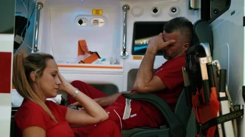 Exhausted emergency workers are resting in the ambulance vehicle Video stock 211820385