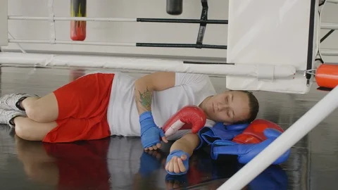 Exhausted Female Boxer Lying on Ring and Having Rest 스톡 동영상 119090861