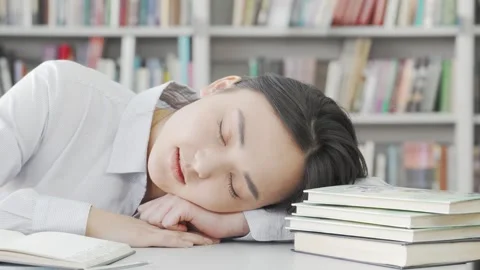 Exhausted female student dozing off at her desk after intense studying Stock Footage 311516029