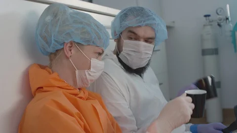 Exhausted Frontline Coronavirus Medical Staff Comforting Each Other On a Coffee Stock Footage 129201341