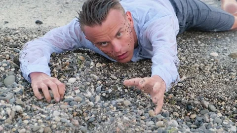 Exhausted man on the seashore asks for help stretching out his hand Stock-Footage 160108354