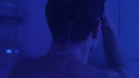 Exhausted man standing under a shower, covering his face, feeling drained and Video stock 304235849