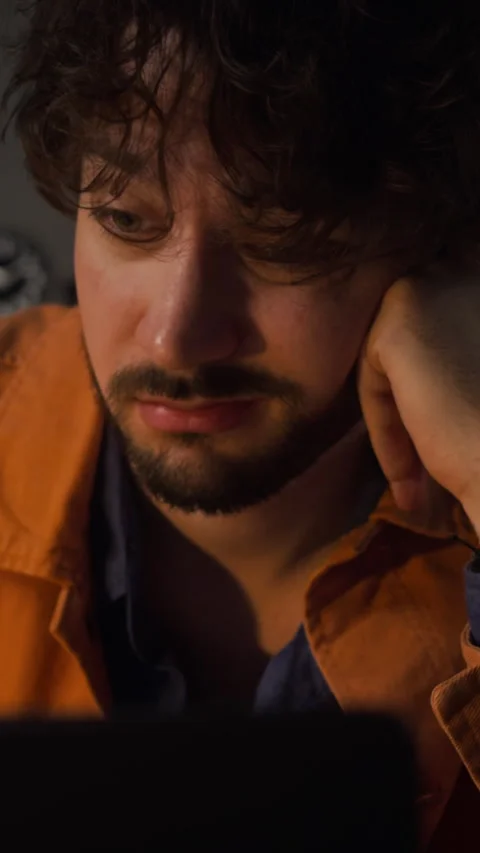 Exhausted Man Staring at Laptop Screen in Dark Office at Night Stock Footage 338419375