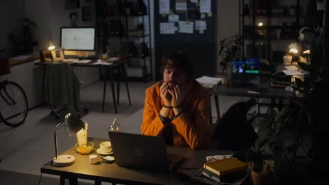 Exhausted Man Working Late on Laptop in Dark Office Feeling Stressed Stock Footage 338414222