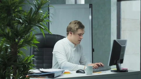 Exhausted-the Manager is sorting out documents at his workplace, the electric Video stock 147157678