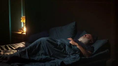 Exhausted middle-aged bearded man tosses and turns in bed, restless sleep Stock Footage 346714388