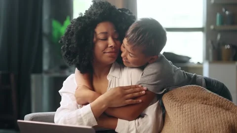 Exhausted mother get struggles while working and son appears to hug Stock Footage 248689419