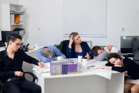 Exhausted office workers resting on their workplace, while having a 5 minute Stock Photos