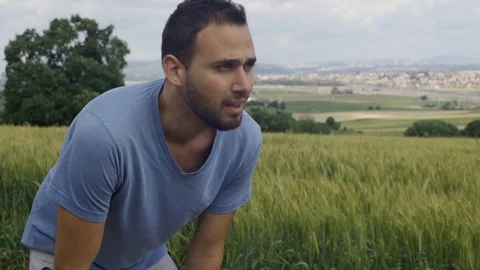 Exhausted runner stops to take a breath and then runs. Set in rural area Stock Footage 107270234