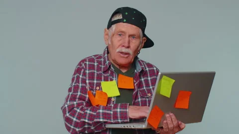 Exhausted senior man with pasted stickers use laptop computer, concentration Stock Footage 190853432