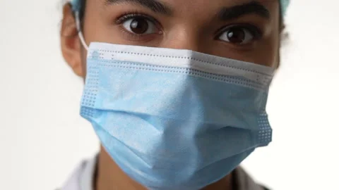 Exhausted at work. Close up of tired young female doctor wearing medical mask Stock Footage 145724295