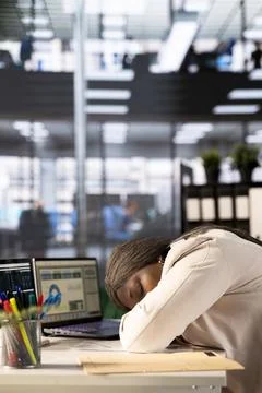 Exhausted worker falling asleep while doing tedious data entry job Stock Photos