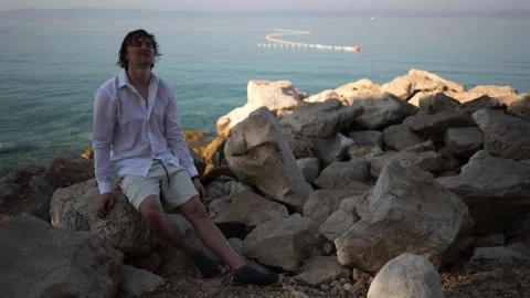 Exhausted young man cannot believe his long awaited seaside vacation has begun Видео 341622841