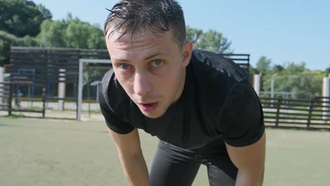 Exhausted young man looks into camera and rests after workout. Covered in sweat Video stock 115932359