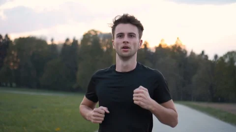 Exhausted young man running marathon during sunset, slow motion Stock Footage 129610168