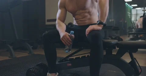 Exhausted young men resting after intensive workout at bench in gym. Handsome Stock-Footage 150454141