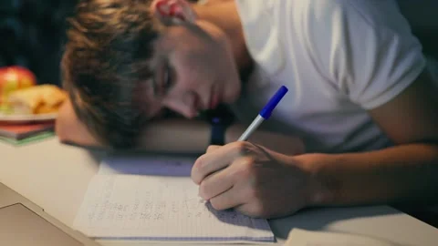Exhausted youth sleeping on his notebook while doing academic homework. Stock Footage 345211102