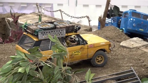 An exhibition of car models and track models. A yellow car drives over tracks 스톡 동영상 124584005
