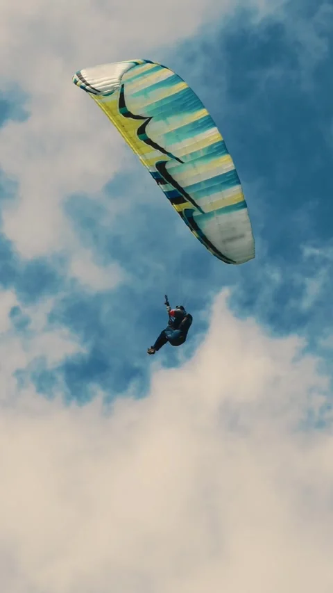 Exhilarating Paragliding Adventure Against a Dramatic Cloudy Sky 動画素材 314318326