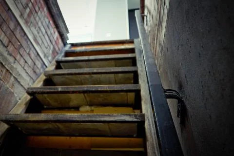 Exit from the brick cellar with a railing up the stairs to the light Stock Photos