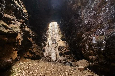Exit from a dark cave with stone steps Foto stock