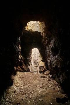 Exit from a dark cave with stone steps Stock Photos