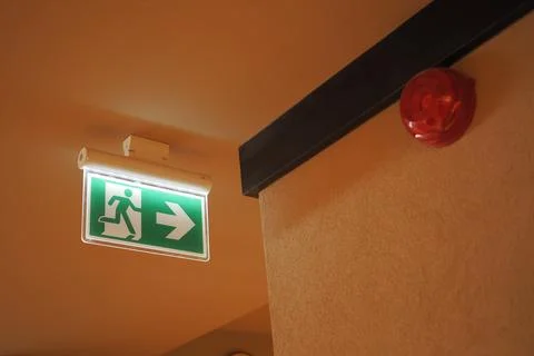 Exit sign with arrow indicating direction in a building interior Stock Photos