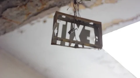 An exit sign hanging from the ceiling of an abandoned building Stock Footage 79333040